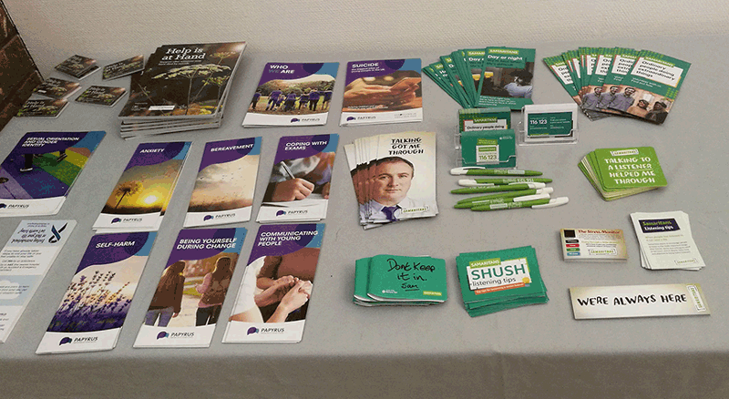 A table of leafets from Samaritans, Papyrus and other support agencies around suicide prevention